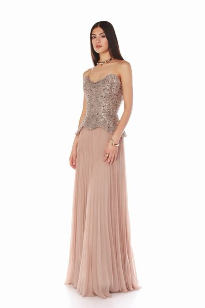 فستان سهرة مزين بتفاصيل بيبلوم وردية اللون مزينة بالترتر